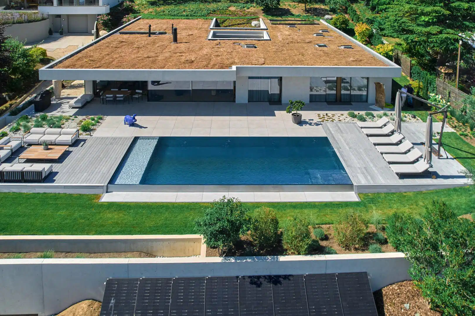 Piscine inox à débordement devant une villa moderne